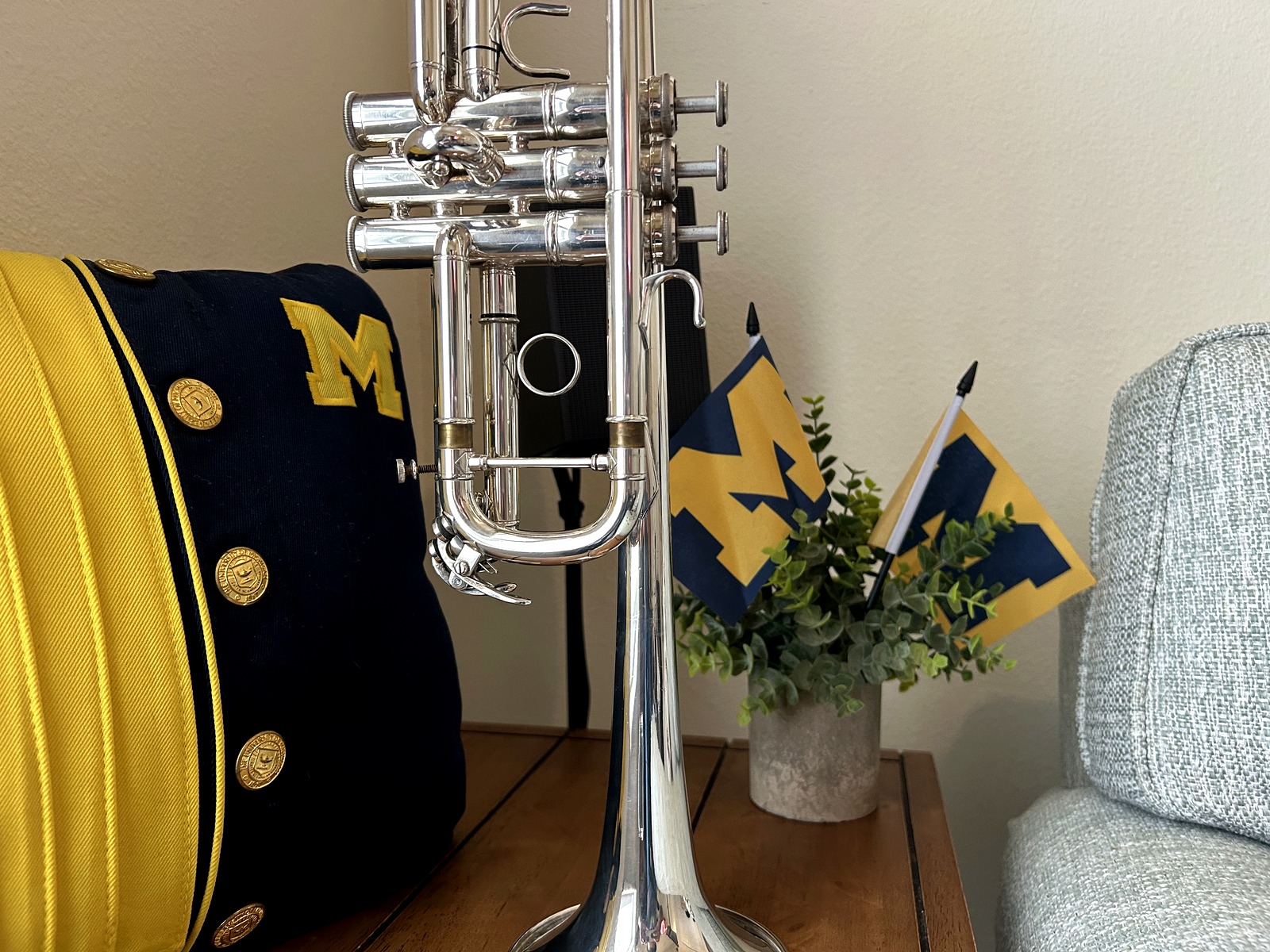 Trumpet displayed beside a University of Michigan marching band uniform